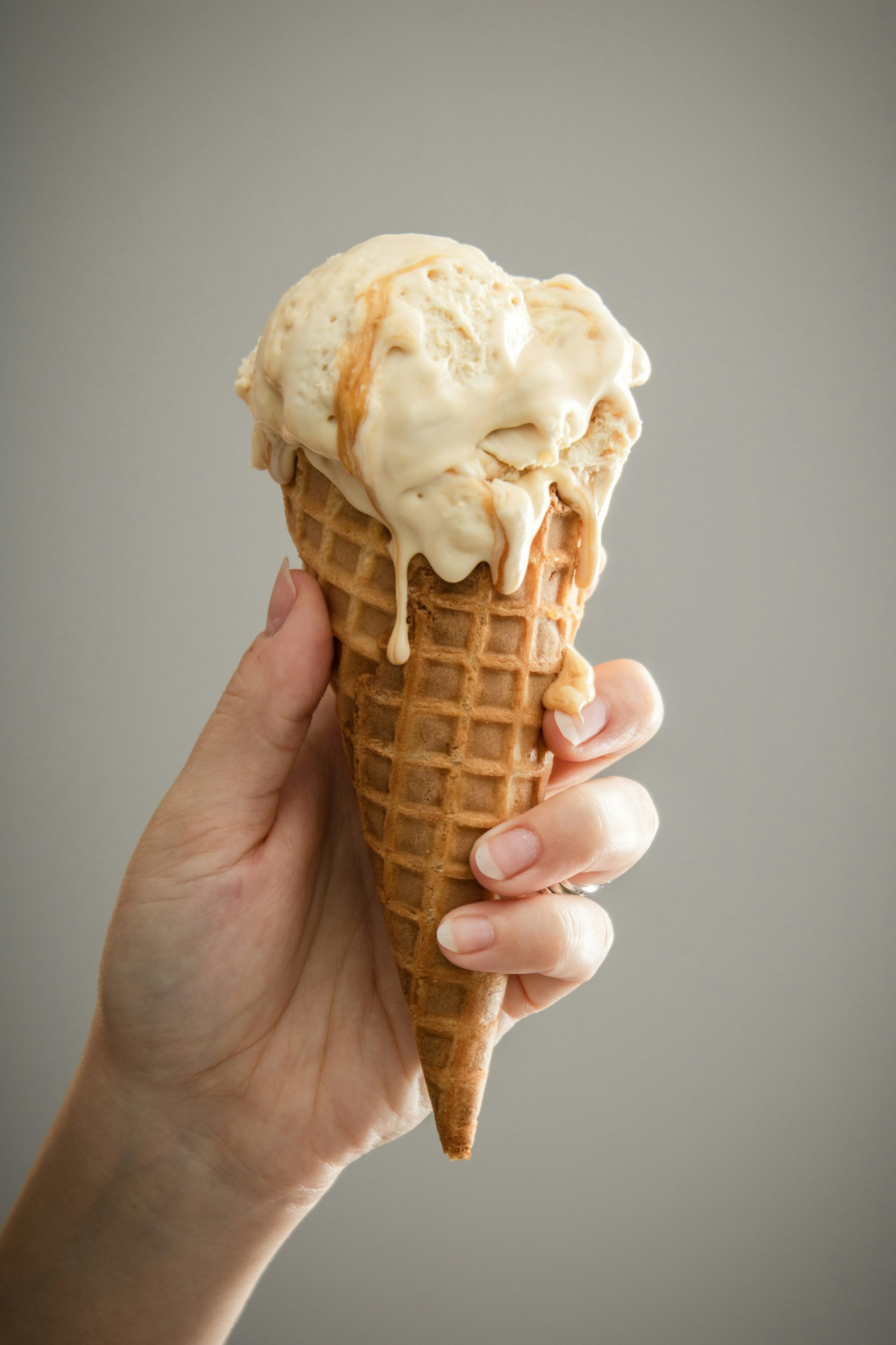 Cornet gaufré garni d'une glace artisanale onctueuse qui commence à fondre
